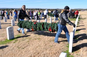 Bryan Correira | Herald Two volunteers carry a pole filled with wreaths at the Central Texas State Veterans Cemetery on Sunday, Jan. 5, 2014. Some 5,000 wreaths that adorned the graves of veterans were removed.